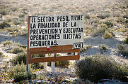 Camping Near El Chevo - Beach - Sign about Illegal Fishing: "El sector pesq. tiene la finalidad de la prevención y ejecutar operaciones ilícitas pesqueras. -Vig."