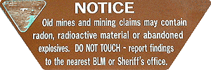 Sign: "NOTICE - Old mines and mining claims may contain radon, radioactive material or abandoned explosives. DO NOT TOUCH - report findings to the nearest BLM or Sheriff's office."